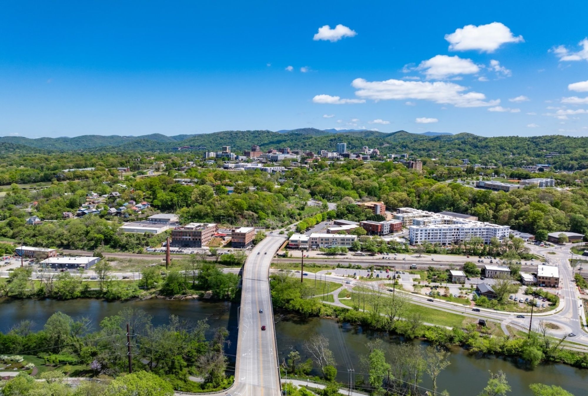 bridge crossing a river with rolling hills in the background