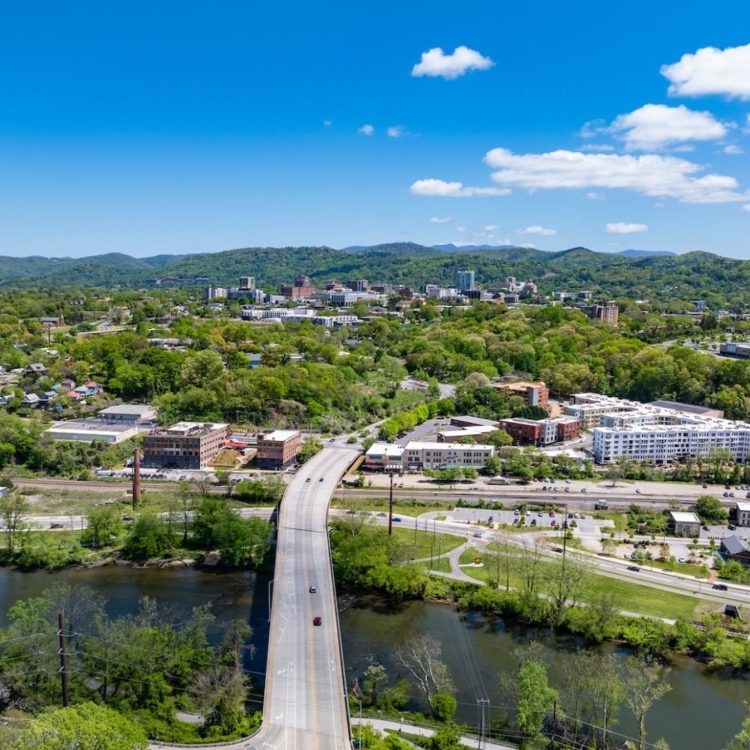 bridge crossing a river with rolling hills in the background