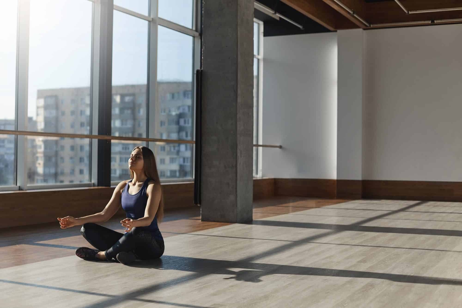 A woman meditating in a large open room