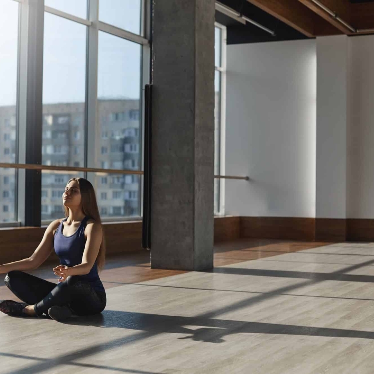 A woman meditating in a large open room